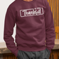Person wearing a maroon sweatshirt with 'So Very Thankful' text against a wooden background